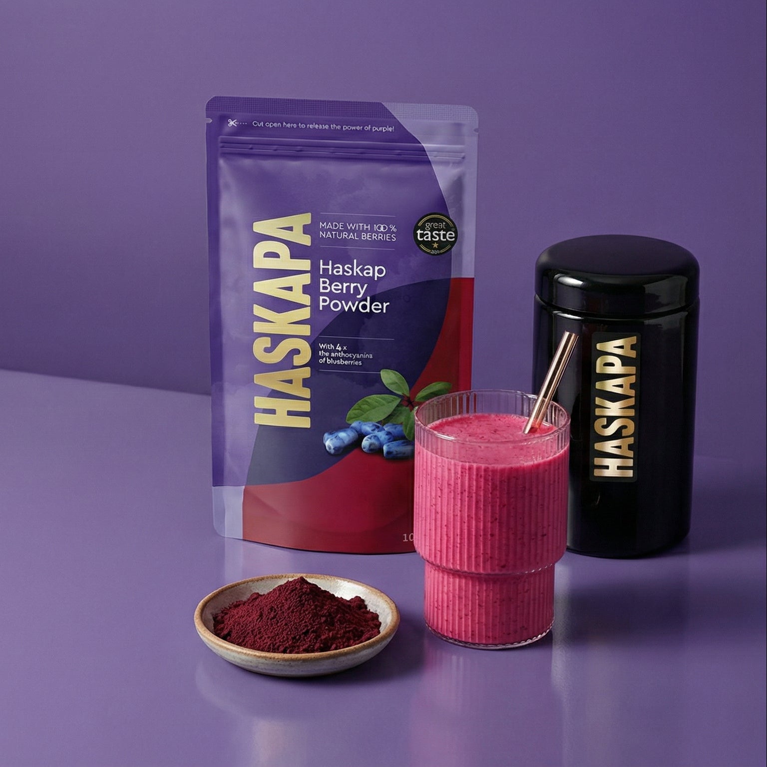 Haskapa berry powder packaging with a pink smoothie and ingredients on a purple background