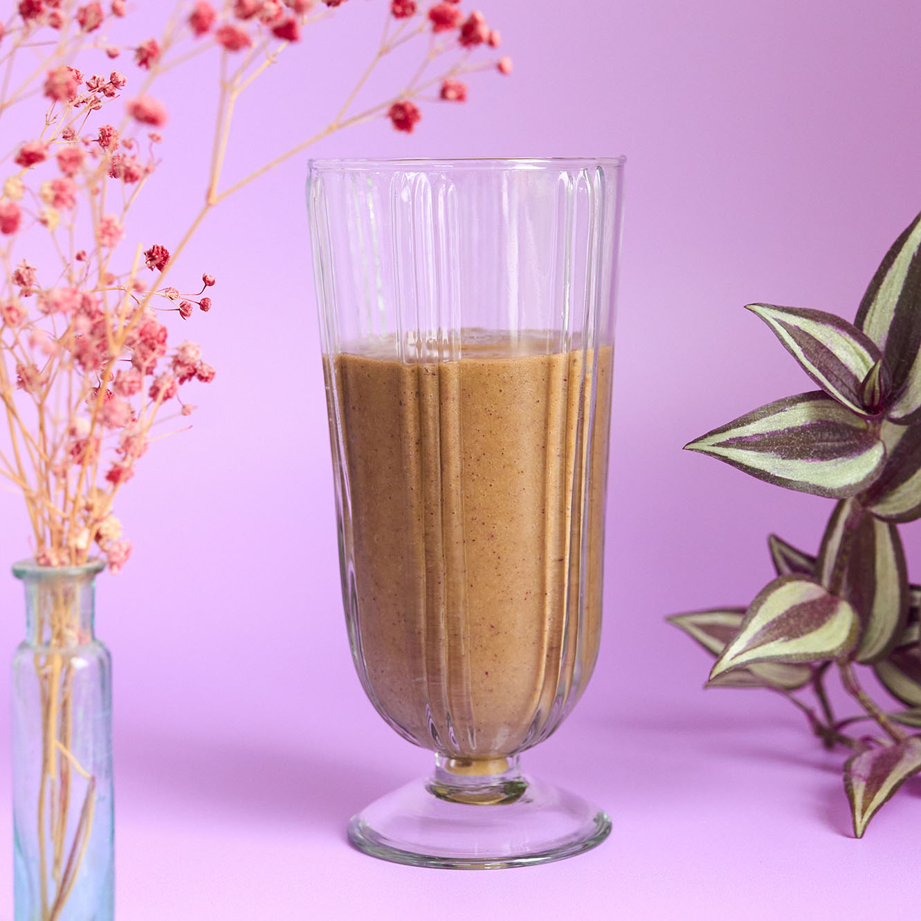 A beige smoothie in a tall glass.